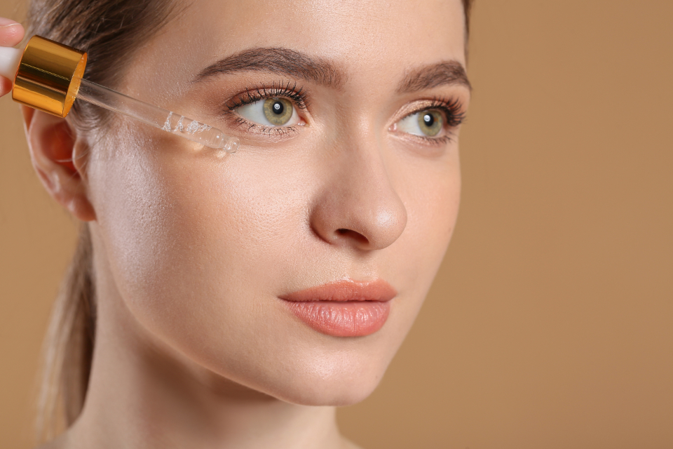 A person applying skincare oil with a dropper in a clean beauty routine