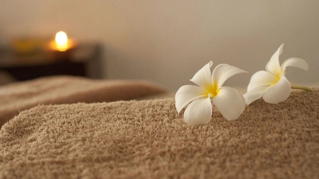 Spa towel with white plumeria flowers for a simple summer evening shower routine