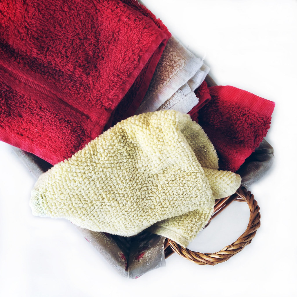 Folded towels in a woven basket for a simple dorm shower caddy routine