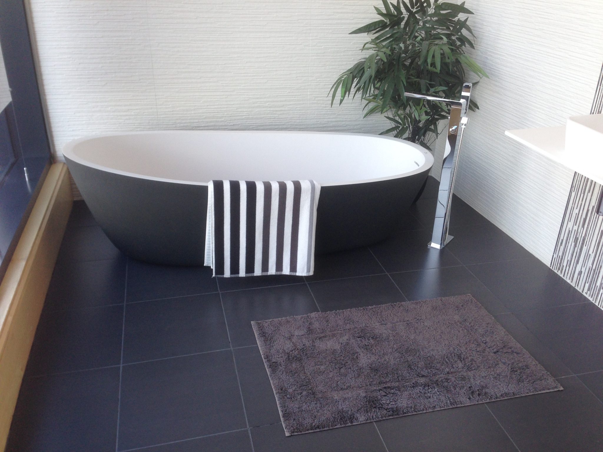 Clean bathroom with towel and green plant for a simple busy morning clean beauty routine