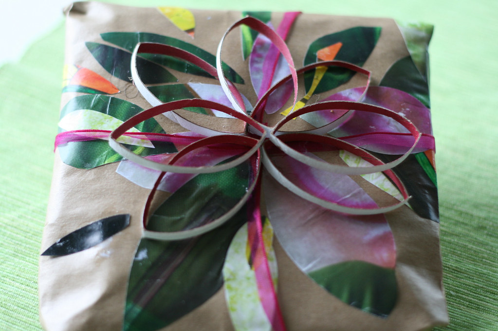 Hand-wrapped gift in kraft paper with colourful botanical details and ribbon