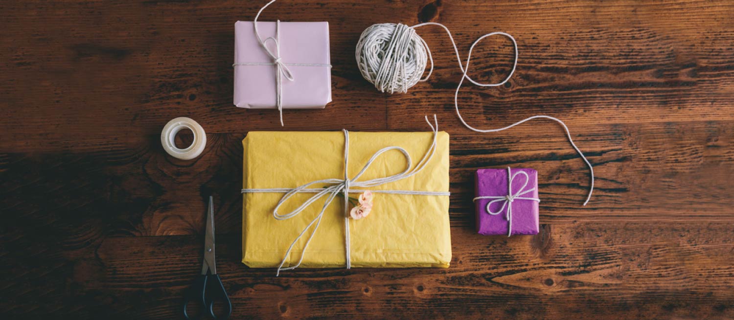 Colorful wrapped gifts with string on a wooden table