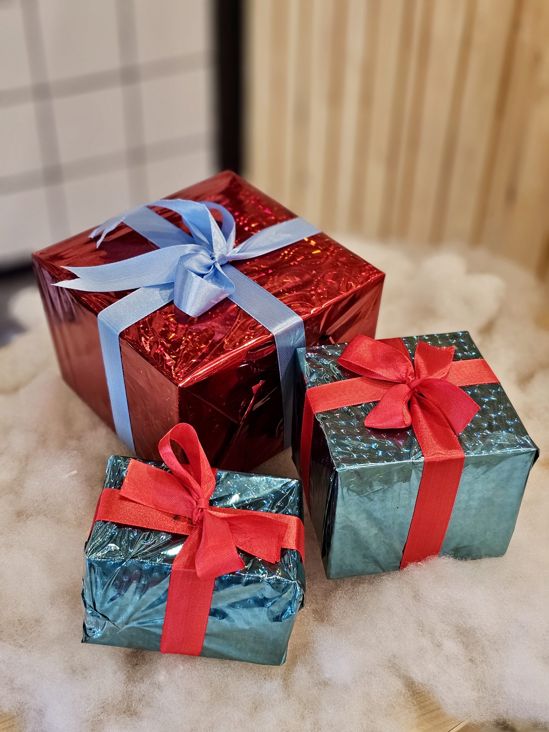 Small festive gifts wrapped in red and teal paper with ribbon bows